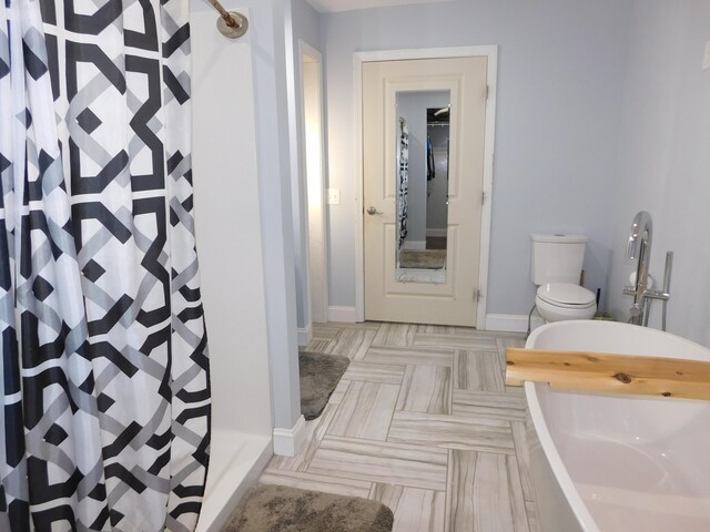 full bath featuring baseboards, a tub to relax in, toilet, and a shower with curtain