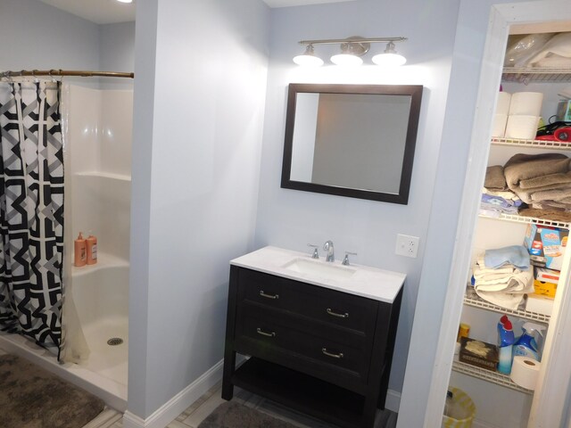 bathroom featuring vanity, baseboards, and a shower with shower curtain