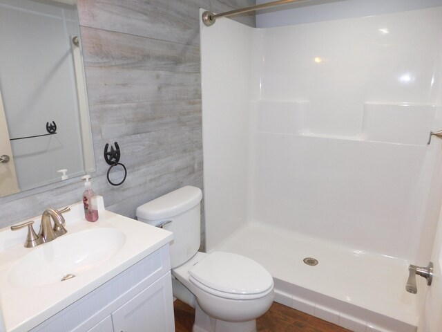 bathroom featuring toilet, a shower stall, and vanity