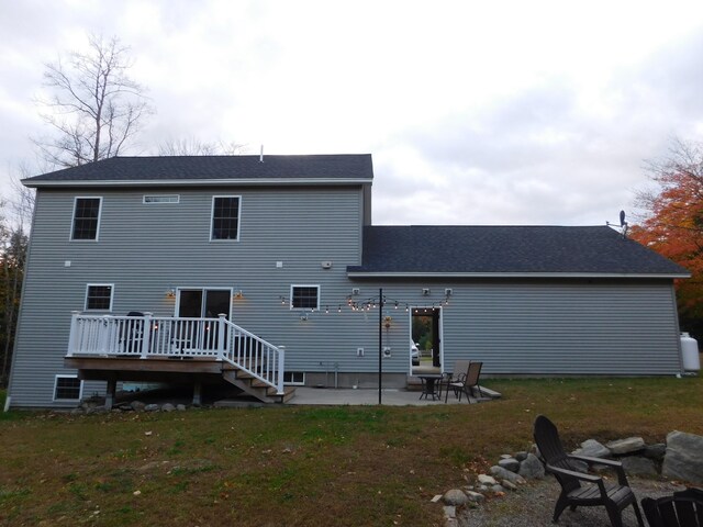 back of property with a yard, a deck, and a patio