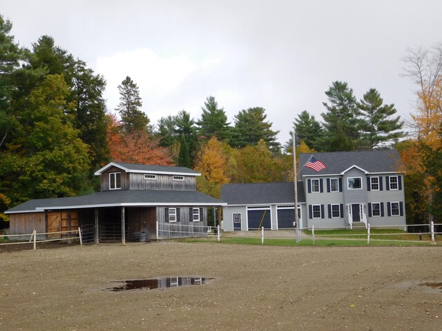 exterior space featuring an attached garage, an exterior structure, and an outdoor structure