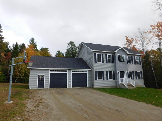 colonial house featuring a shingled roof, a front yard, dirt driveway, and an attached garage