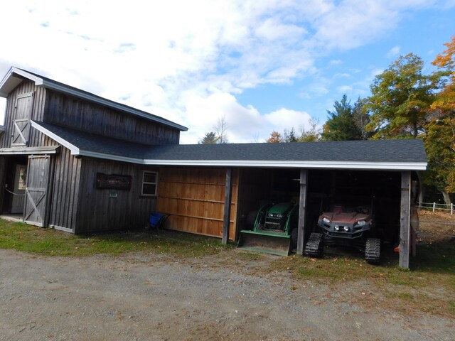 view of outdoor structure featuring a carport and an outbuilding