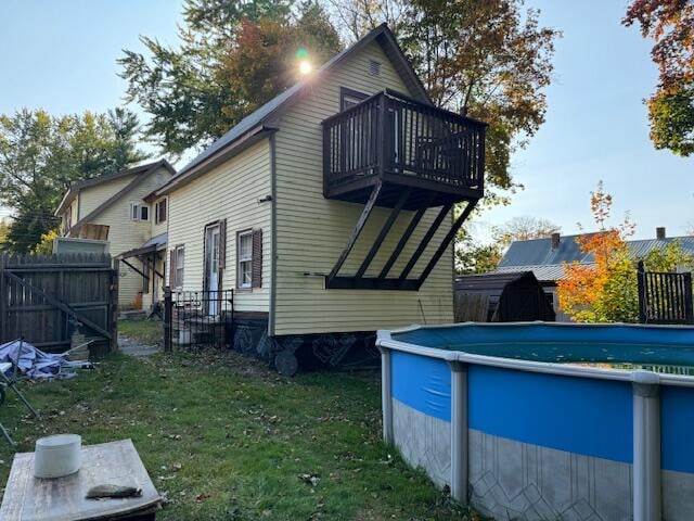 back of property featuring a lawn and a balcony