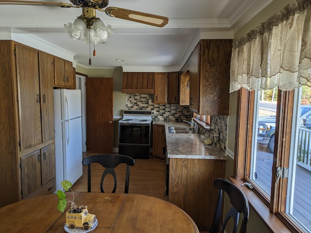kitchen with a sink, range with electric cooktop, freestanding refrigerator, a ceiling fan, and tasteful backsplash