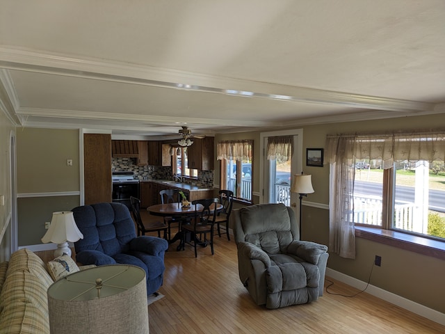 living room featuring crown molding, ceiling fan, sink, and light hardwood / wood-style floors