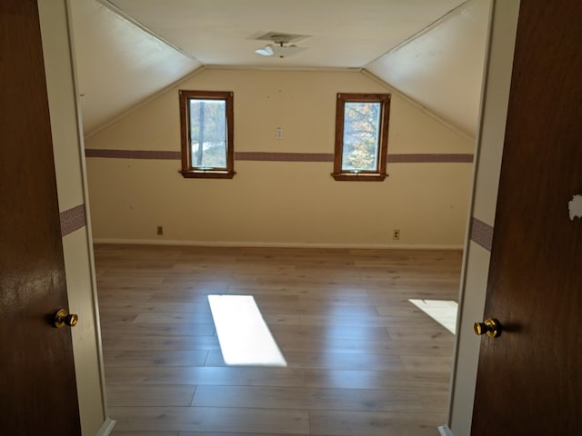 bonus room with vaulted ceiling and light hardwood / wood-style flooring