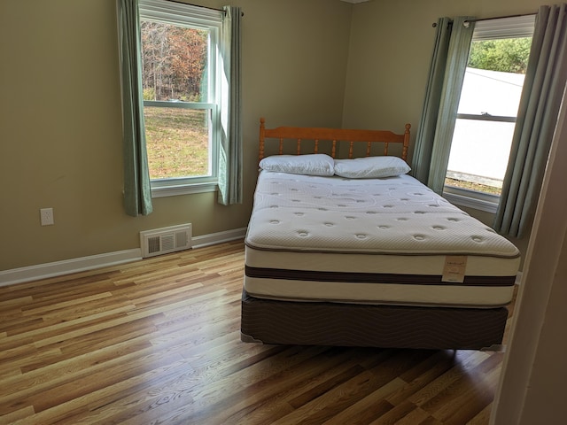 bedroom featuring hardwood / wood-style flooring and multiple windows