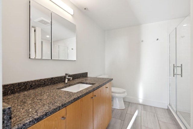 bathroom with vanity, a shower with shower door, and toilet