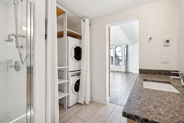 washroom with sink and stacked washer and clothes dryer