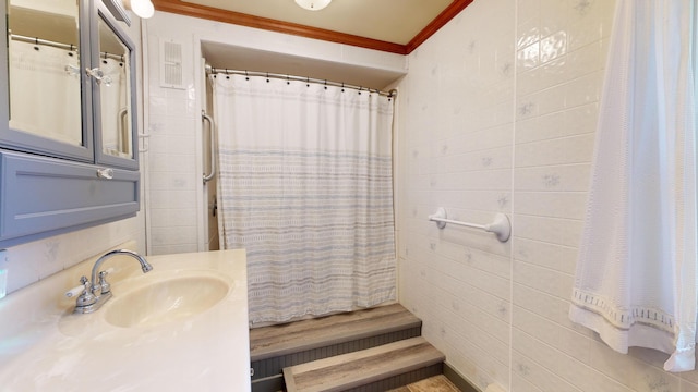 bathroom featuring vanity, ornamental molding, walk in shower, and tile walls