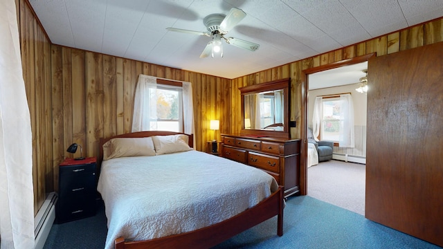 bedroom featuring wood walls, a baseboard radiator, multiple windows, and ceiling fan