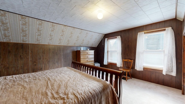 bedroom with multiple windows, carpet flooring, lofted ceiling, and wooden walls