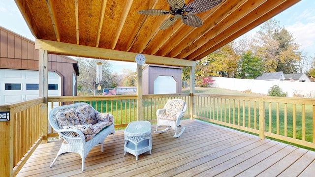 wooden terrace featuring a yard and ceiling fan