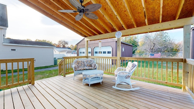 deck with a yard, ceiling fan, a garage, and an outdoor structure