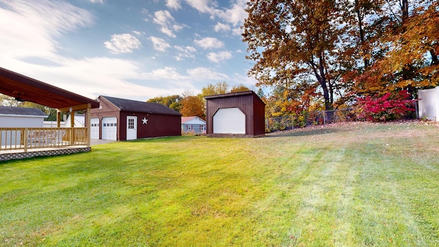 view of yard with a wooden deck, a garage, and an outdoor structure