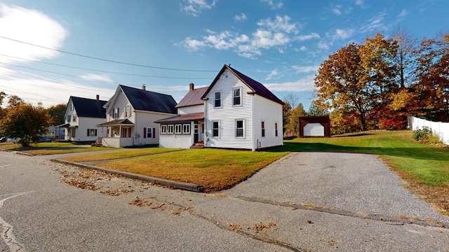 view of front of house with an outdoor structure, a garage, and a front lawn