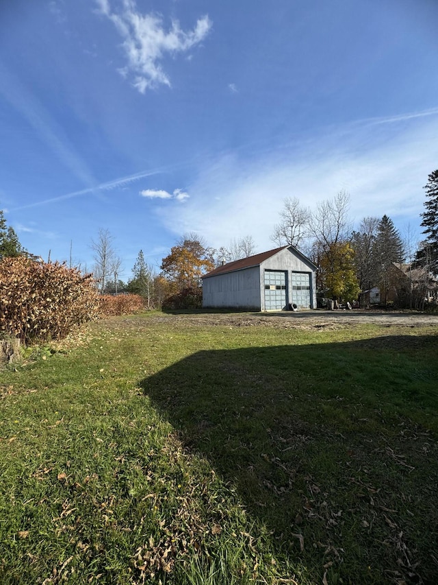 view of yard with a garage and an outbuilding