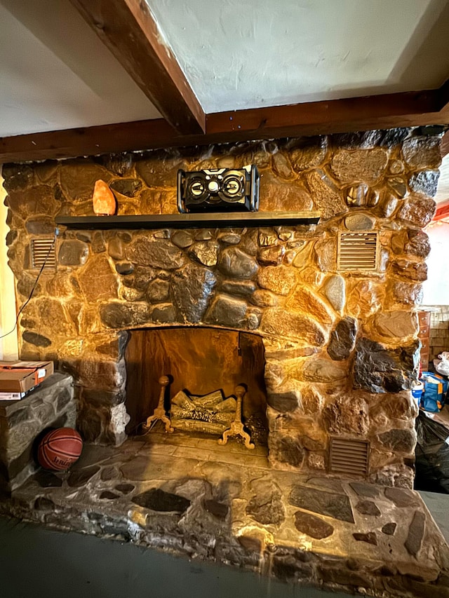 details with a stone fireplace and beamed ceiling