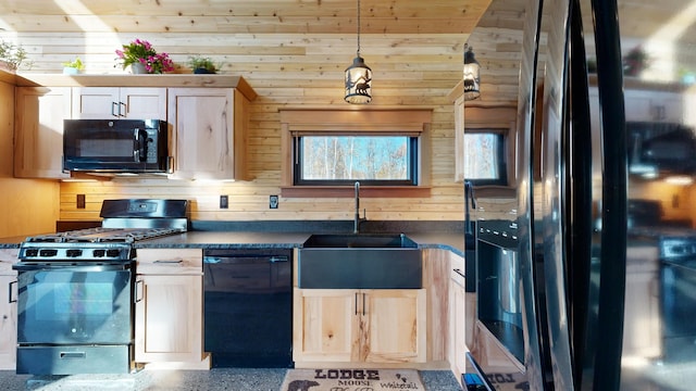 kitchen with black appliances, wood walls, and sink