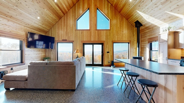 living room with wooden walls, wood ceiling, and high vaulted ceiling