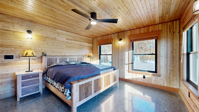 bedroom featuring ceiling fan, wood walls, wooden ceiling, and multiple windows