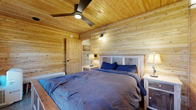 bedroom with ceiling fan, wooden walls, and wooden ceiling