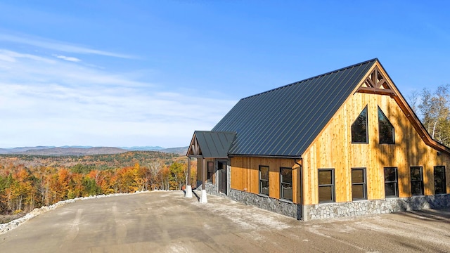 view of property exterior with a mountain view and an outbuilding