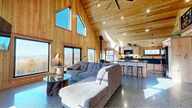 living room with ceiling fan, high vaulted ceiling, plenty of natural light, and wood ceiling