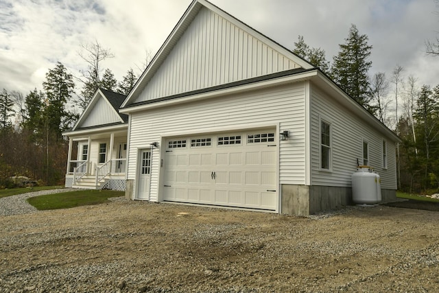 LOT8 Ward Rd, Sebago, ME 04029 - view of side of property with dirt driveway, board and batten siding, a garage, and a porch
