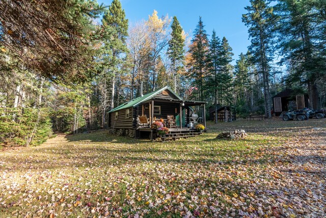 449 Porter Nadeau Rd, Eustis, ME 04936 - rear view of house featuring log exterior, an outbuilding, a yard, and a view of trees