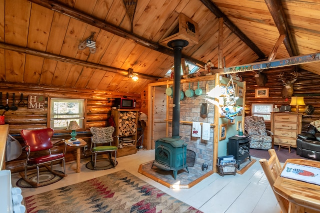 living room featuring a wood stove, beam ceiling, wooden ceiling, and rustic walls