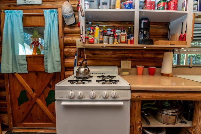 kitchen with log walls and white stove