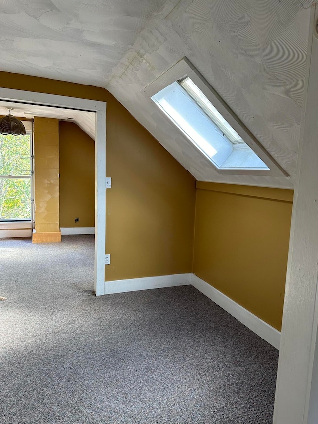 additional living space with carpet flooring, lofted ceiling, and a baseboard heating unit