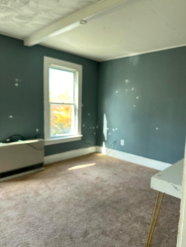 unfurnished bedroom with beam ceiling and carpet floors