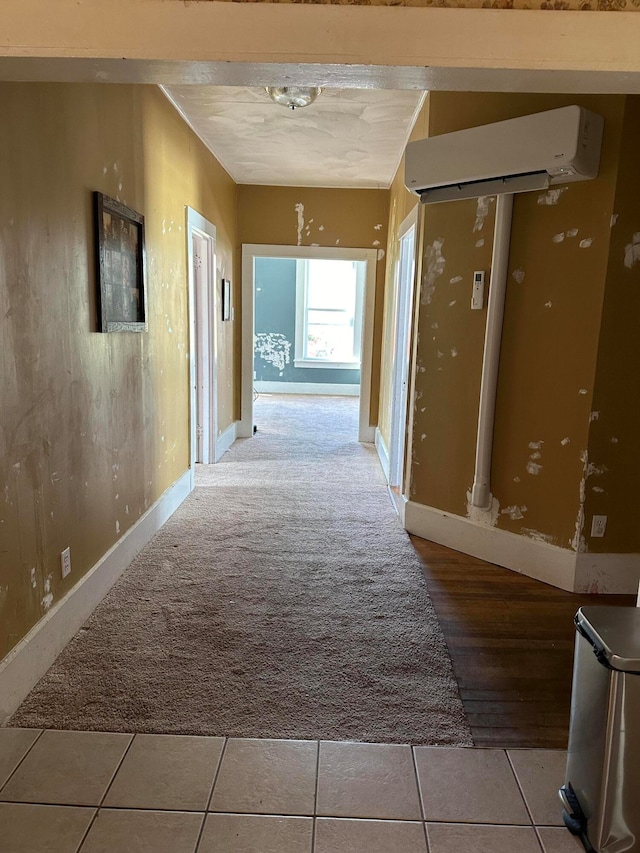 hallway featuring a wall unit AC and light tile patterned floors