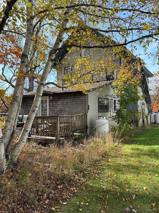 rear view of house featuring a yard and a wooden deck