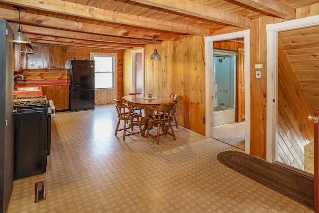 dining area featuring sink, wooden ceiling, wooden walls, and beamed ceiling