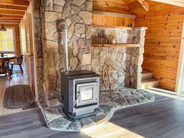 interior details with wooden walls, hardwood / wood-style floors, and a wood stove