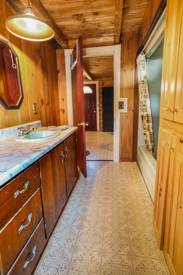 bathroom featuring beam ceiling, wooden ceiling, and wood walls