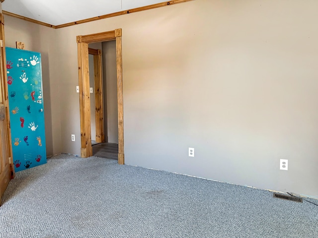 empty room featuring carpet flooring and crown molding