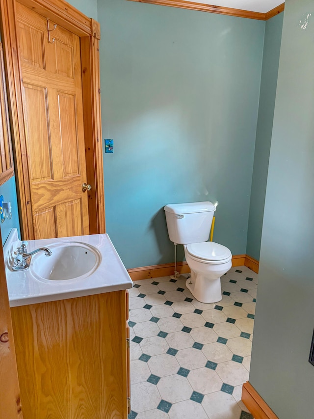 bathroom with crown molding, vanity, and toilet