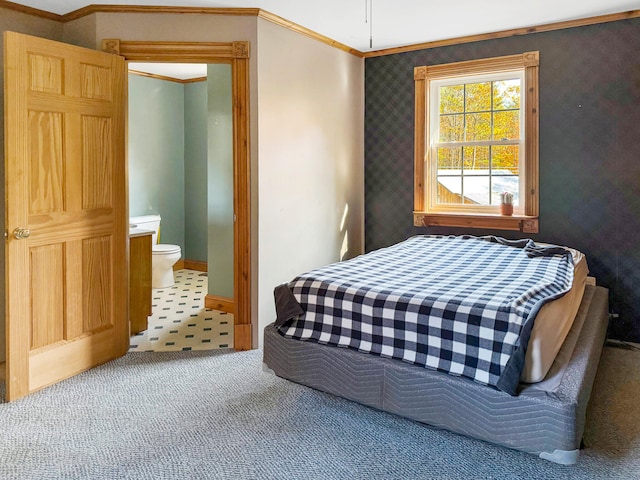 bedroom with connected bathroom, crown molding, and carpet flooring