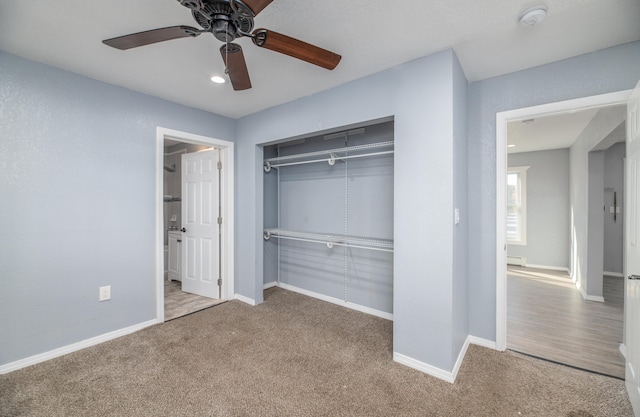 unfurnished bedroom with a closet, ceiling fan, light carpet, and a baseboard radiator