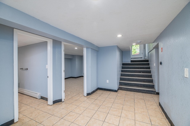 stairway with baseboard heating and tile patterned floors