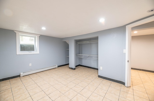 unfurnished bedroom featuring a closet, baseboard heating, and light tile patterned floors