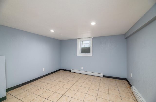 tiled empty room featuring baseboard heating