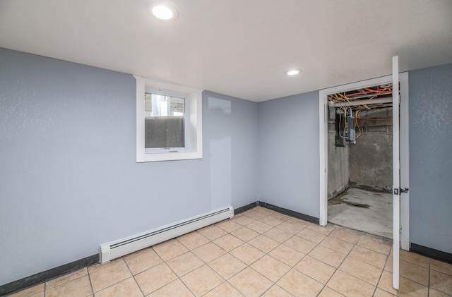 basement with electric panel, a baseboard radiator, and light tile patterned floors