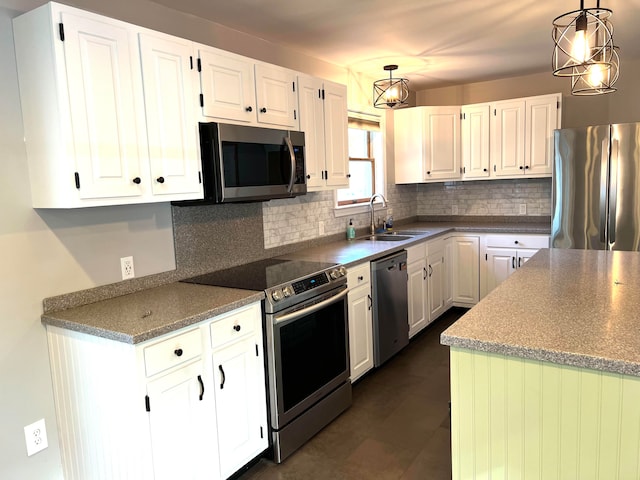 kitchen featuring white cabinetry, stainless steel appliances, hanging light fixtures, and sink