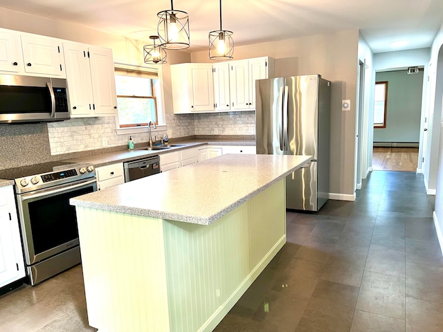 kitchen featuring appliances with stainless steel finishes, a center island, pendant lighting, and white cabinets